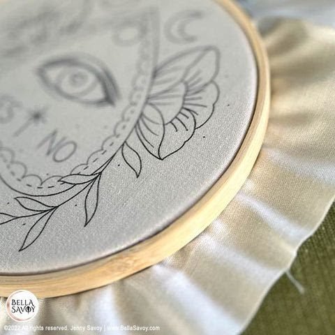 close up view of fabric with an embroidery pattern hooped and ready to be stitched