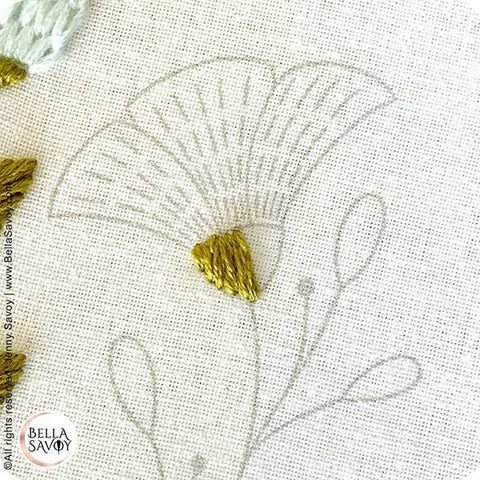 half of a space on a flower filled in with the satin stitch