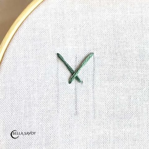 three vertical parallel guidelines with two stitches that start at the top and crosses over each other at the center and ends near the center