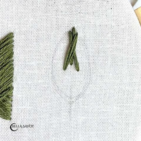 leaf template with a straight stitch at the top center and an 'X' stitched over it.