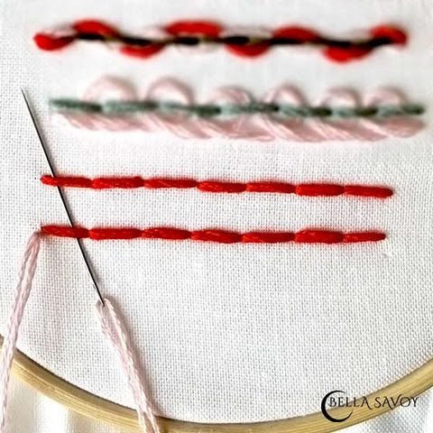 2 horizontal parallel back stitches in red. Needle with pink thread sliding up 1st stitch in both rows