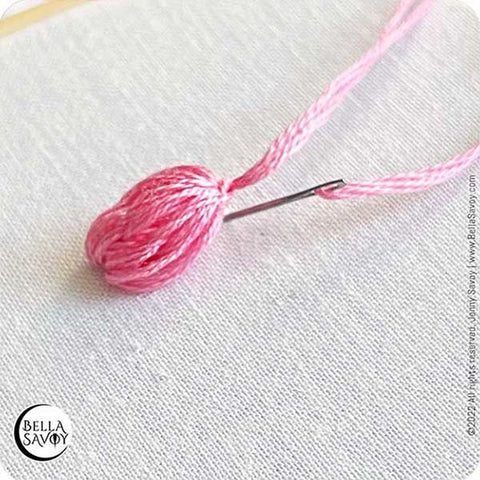 popcorn lazy daisy stitch being stitched to fabric.