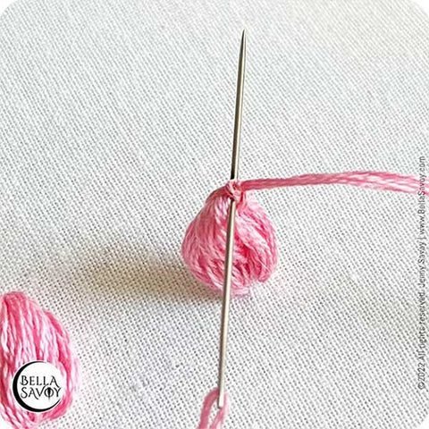 needle going through the top of popcorn lazy daisy stitch