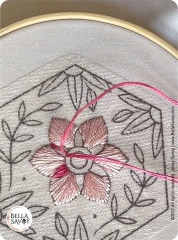 flower embroidery stick and stitch stickers next to a finished pattern
