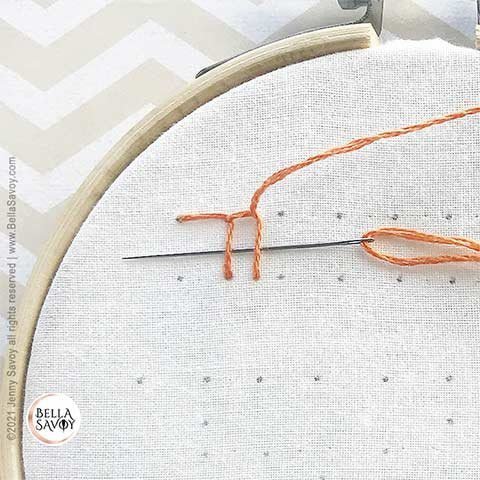 needle slipped under two blanket stitches