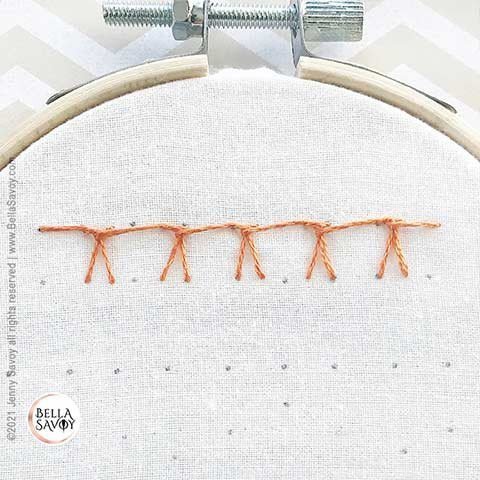 row of german blanket stitches in orange